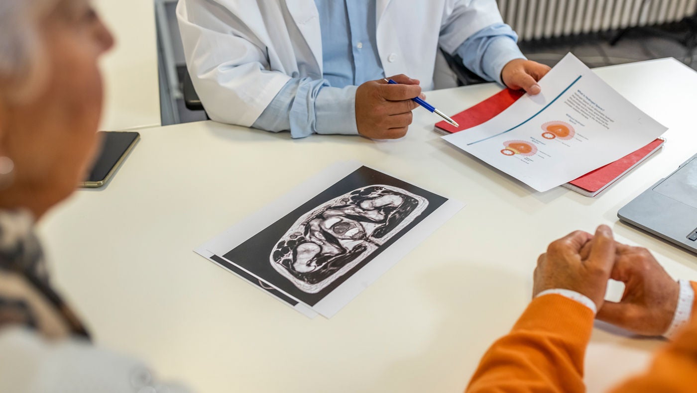 Ärztin erklärt älteren Patienten Harninkontinenz