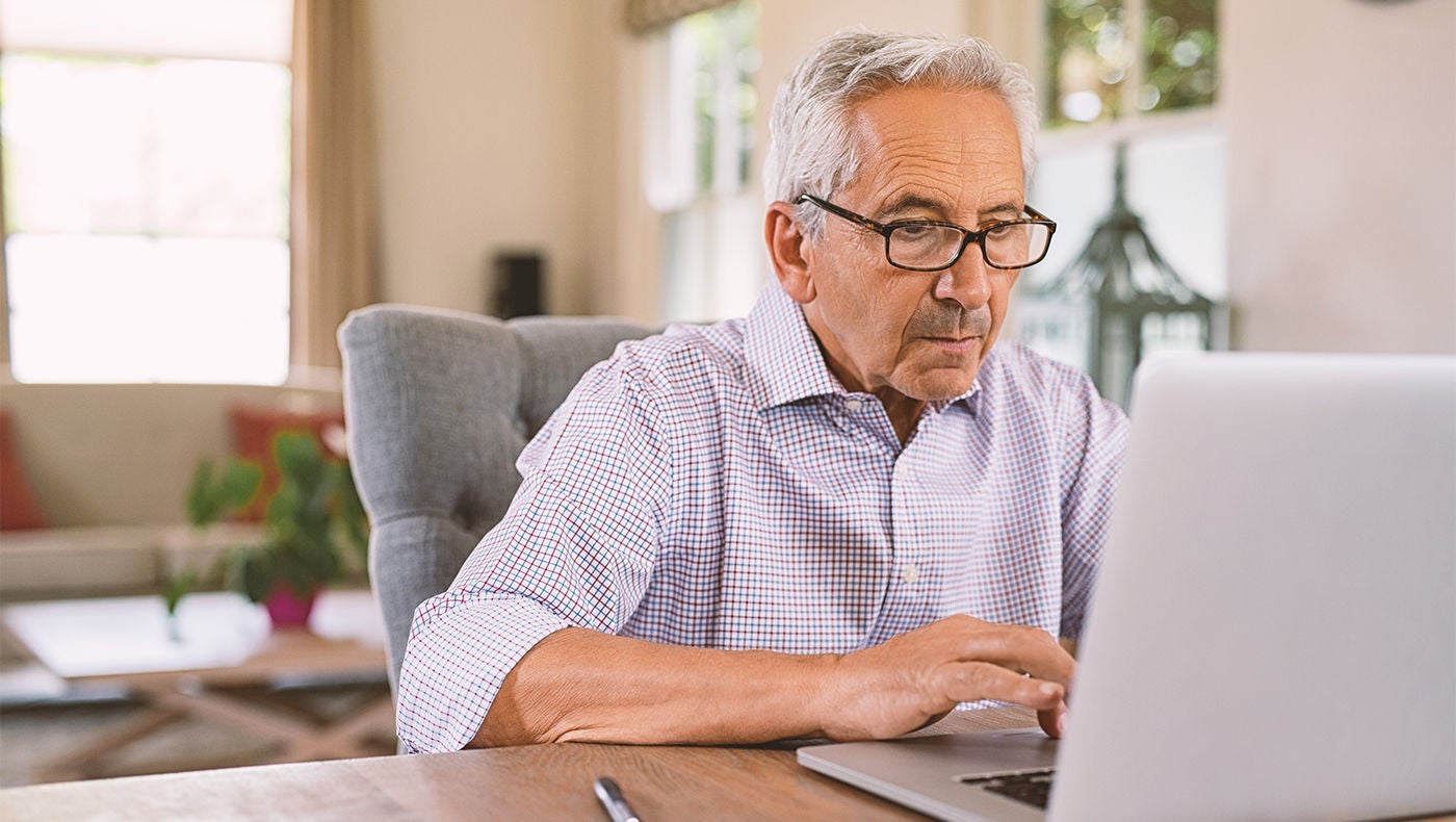 Mann recherchiert urologische Erkrankungen am Laptop