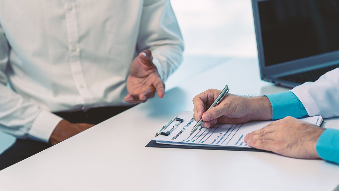 Mann im Gespräch mit Arzt über männliches Schlingensystem