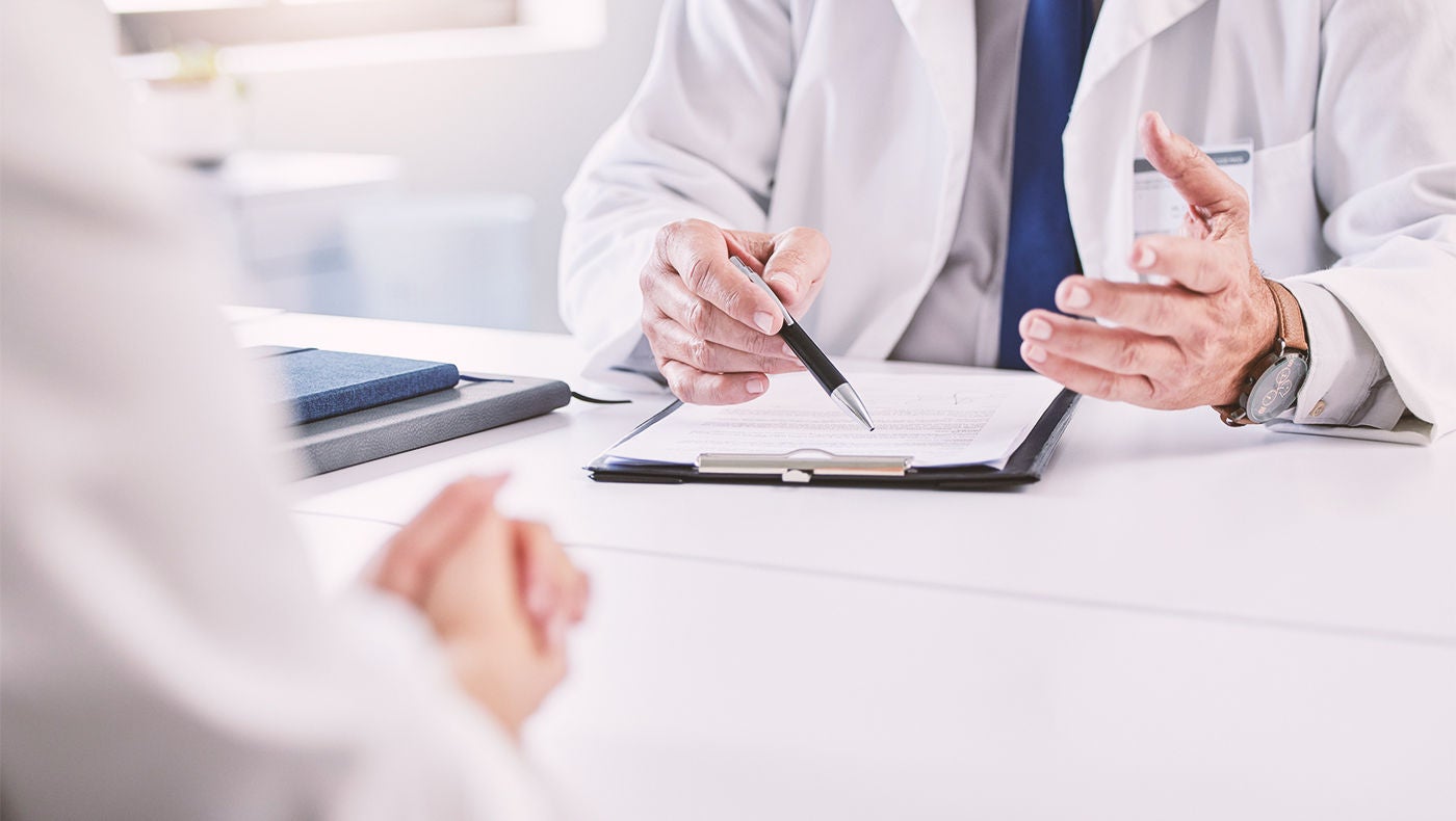 Arzt mit Notizblock im Gespräch mit Patient über Hydrogel-Spacer