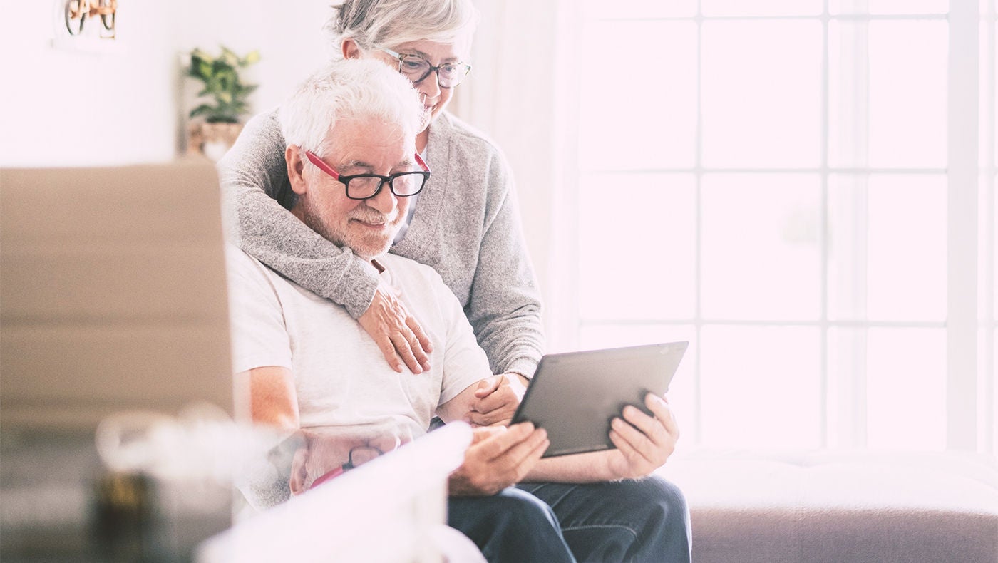 Mann und Ehefrau lesen auf dem Tablet über Impotenztherapie