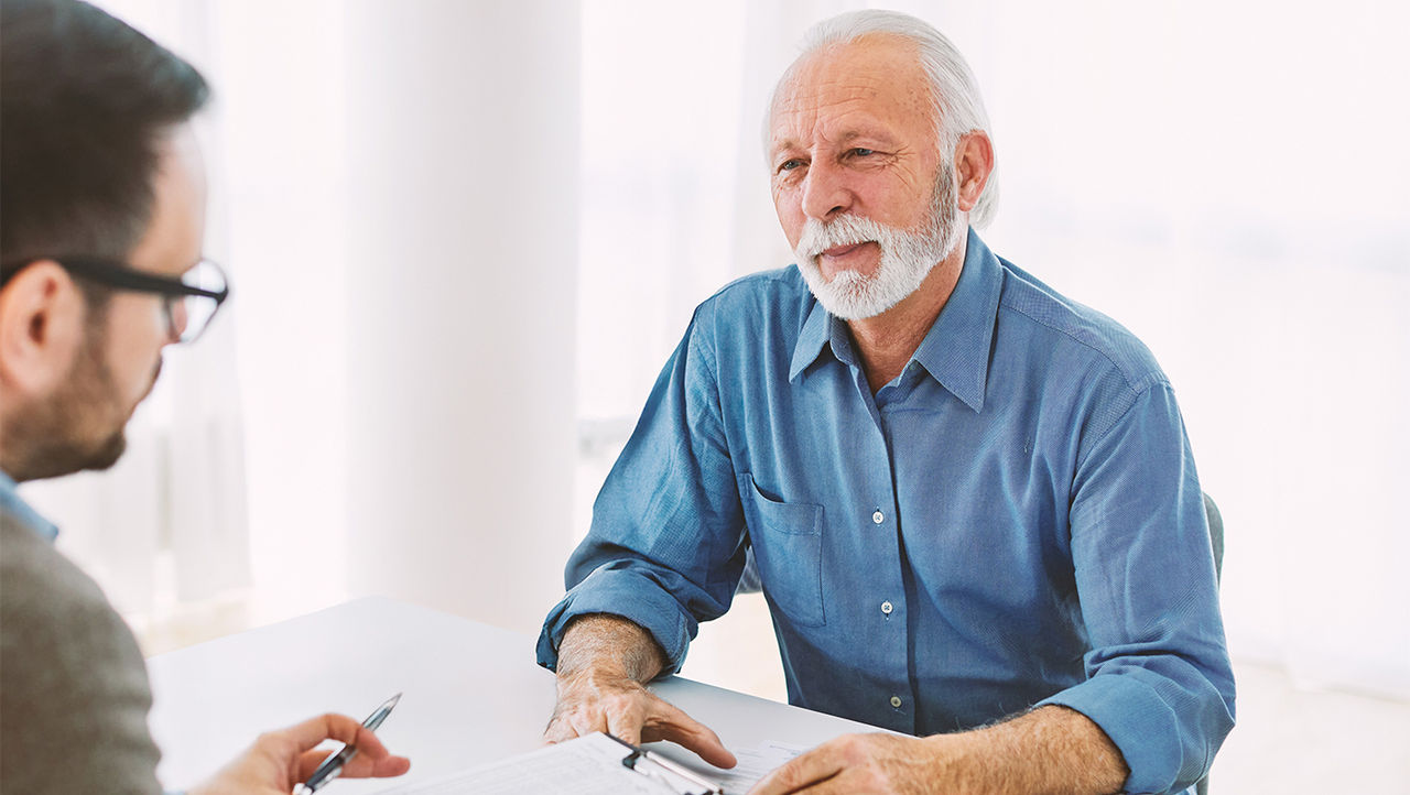 Mann beim Arztbesuch, spricht über männliche Inkontinenz