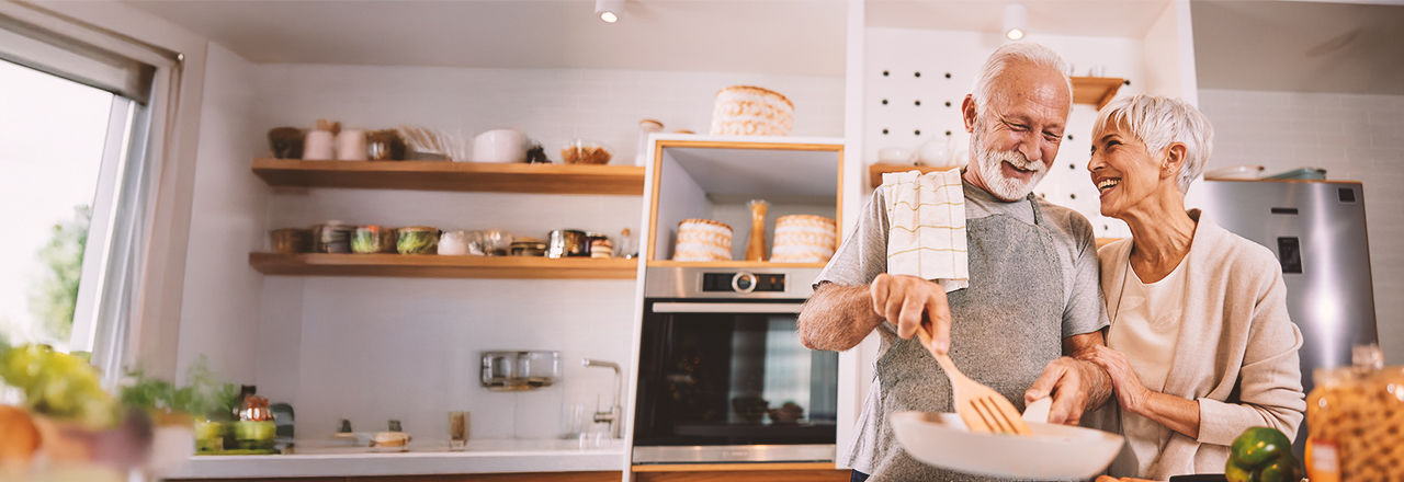 Älteres Paar kocht in Küche und spricht über vergrößerte Prostata