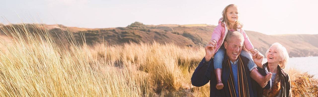 Älteres Paar mit Enkelin auf einem Feld, der Großvater leidet an Prostatakrebs